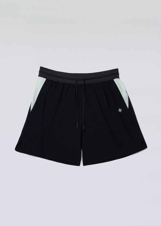 Black and green active shorts with elastic waistband and zippered pockets.