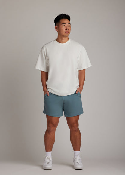 Midnight emerald active shorts with elastic drawstring, versatile fabric, and zippered mesh pockets.