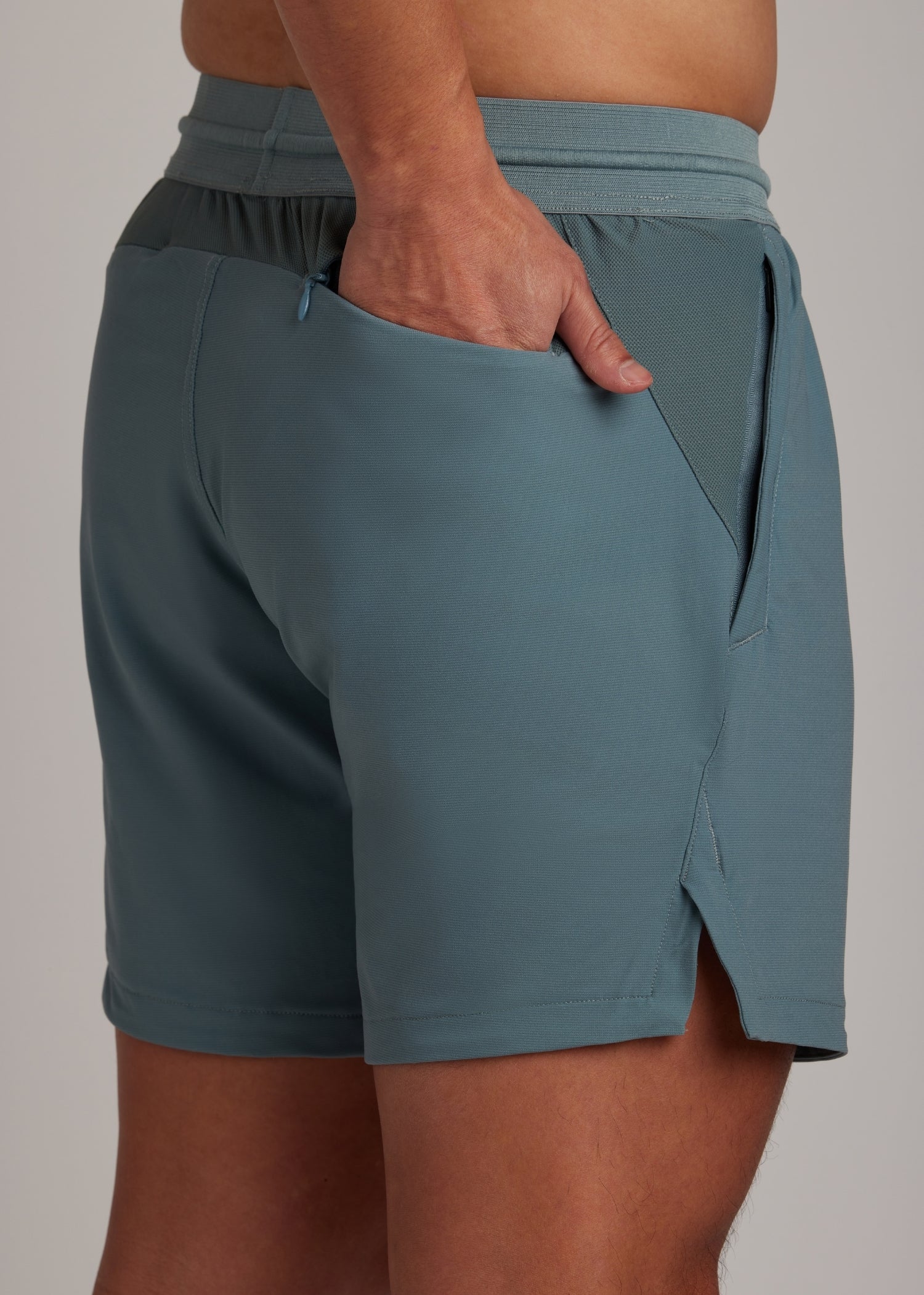 Versatile Midnight Emerald active shorts with mesh-lined zippered front pockets.
