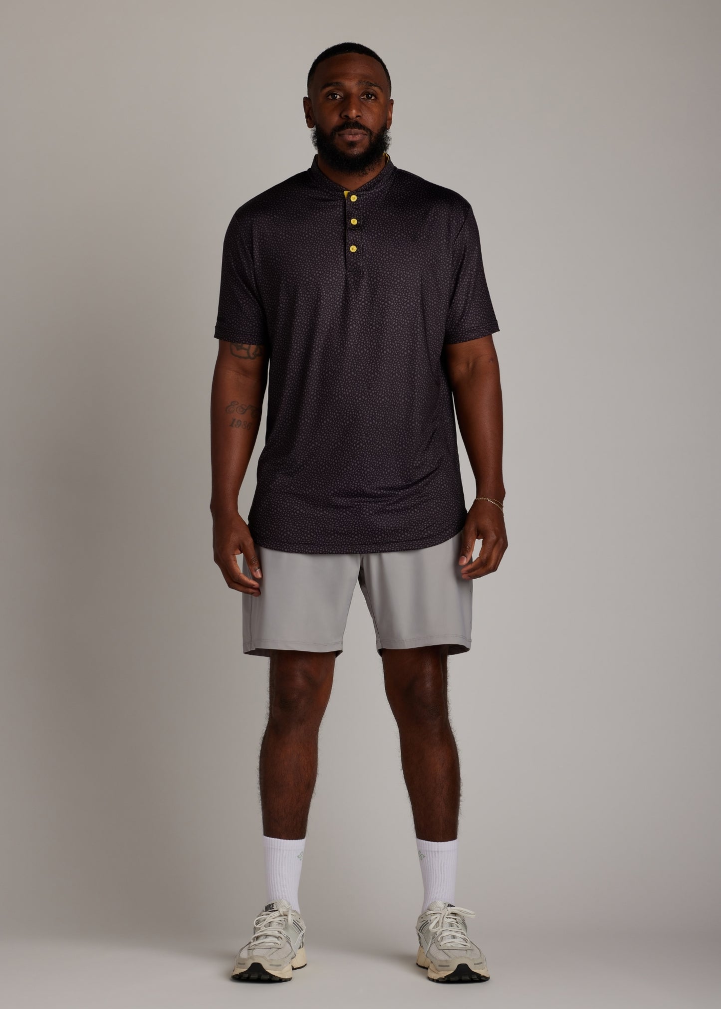 Snake skin pattern bladed collar polo shirt in performance fabric for modern athletic style.