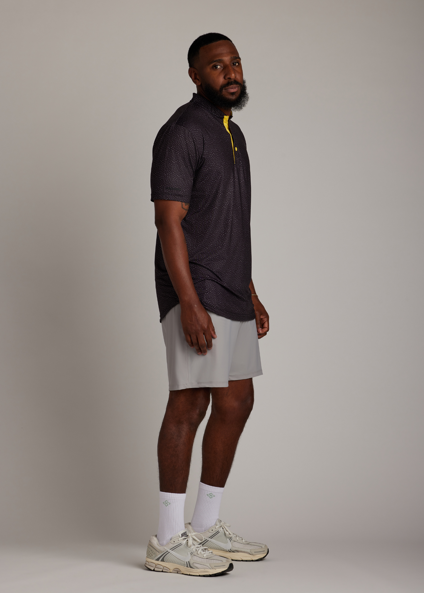 Snake skin pattern bladed collar polo shirt in performance fabric for modern athletic style.