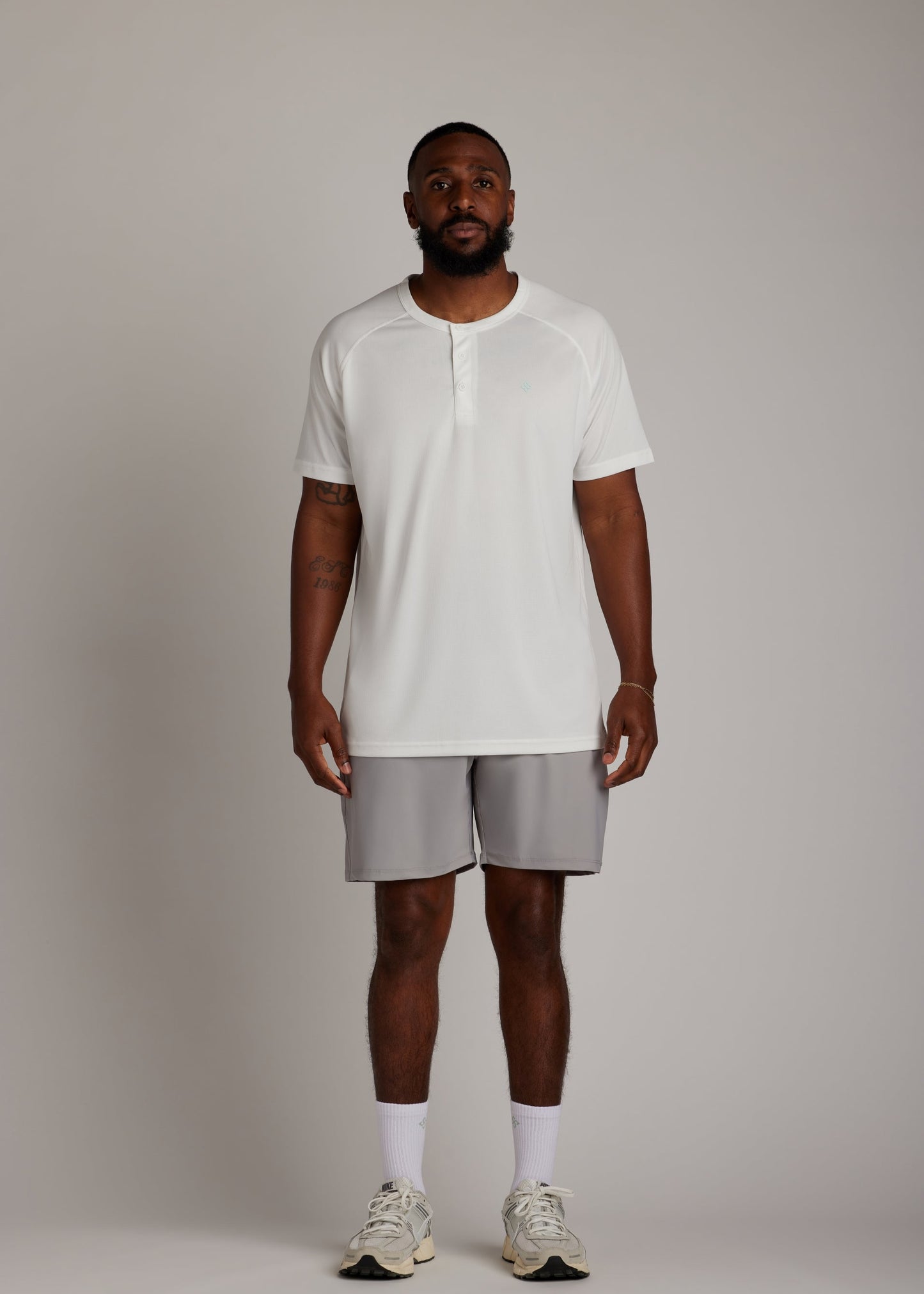 White 3-button polo shirt, breathable micro-mesh fabric, modern sport collar for golf.