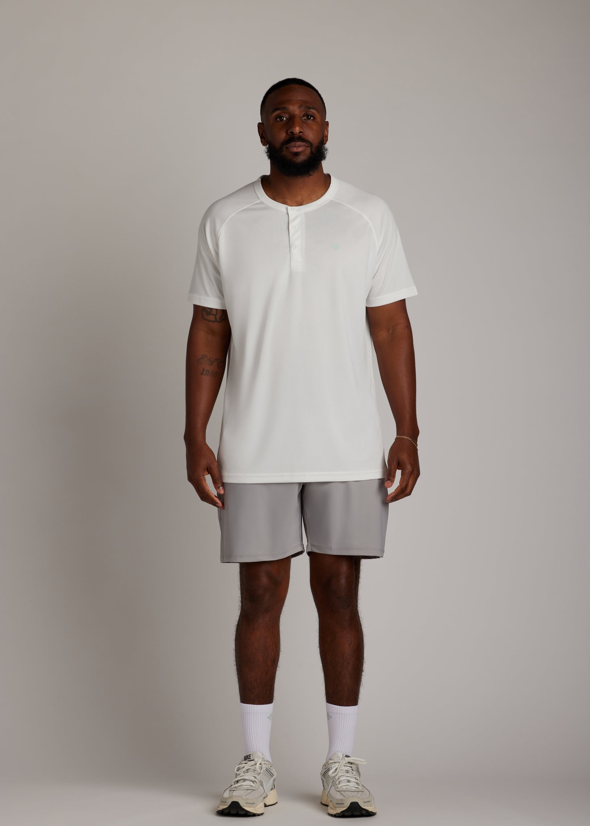 White 3-button polo shirt, breathable micro-mesh fabric, modern sport collar for golf.