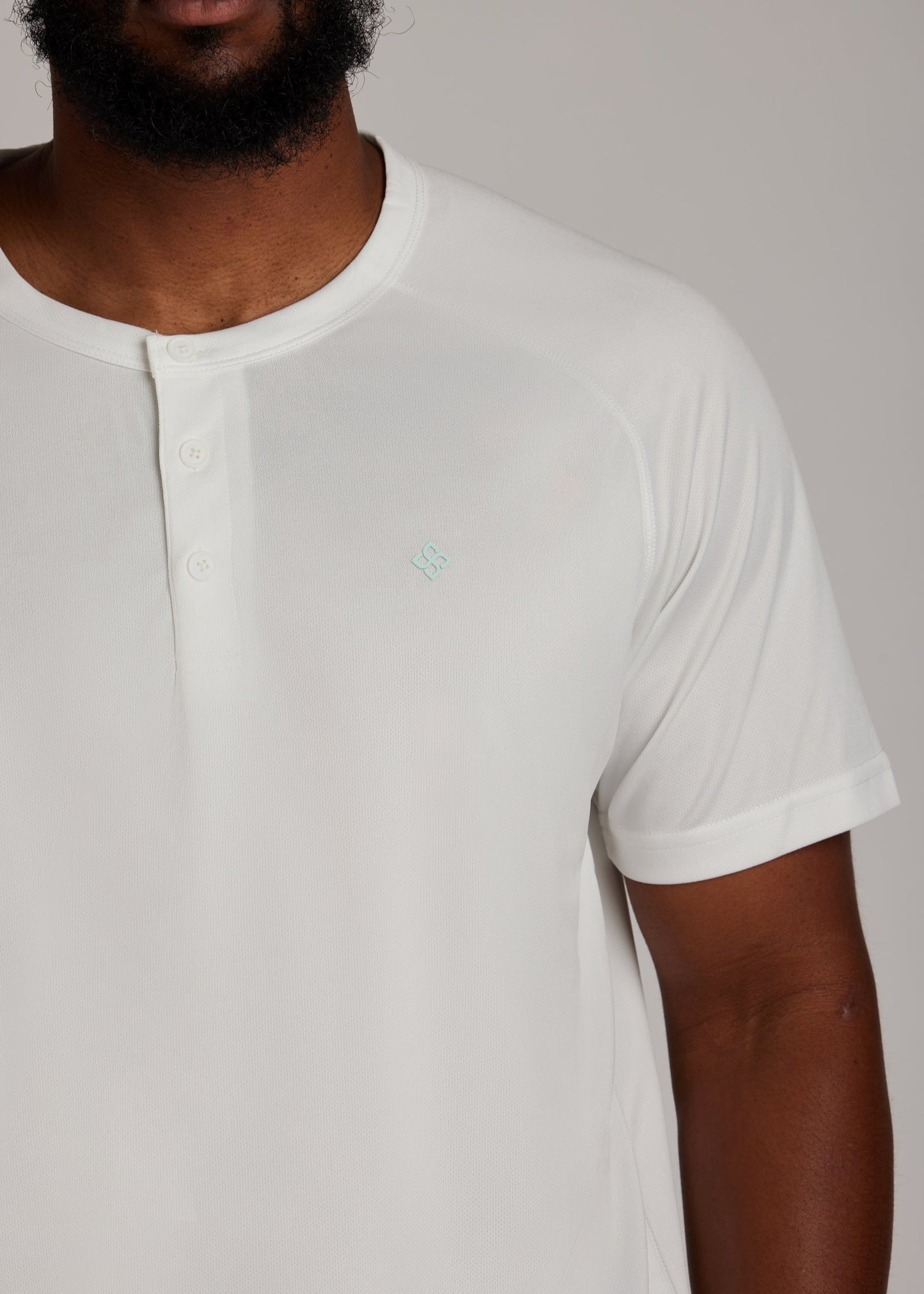 White 3-button sport tee with modern collar, breathable micro-mesh fabric for active wear.
